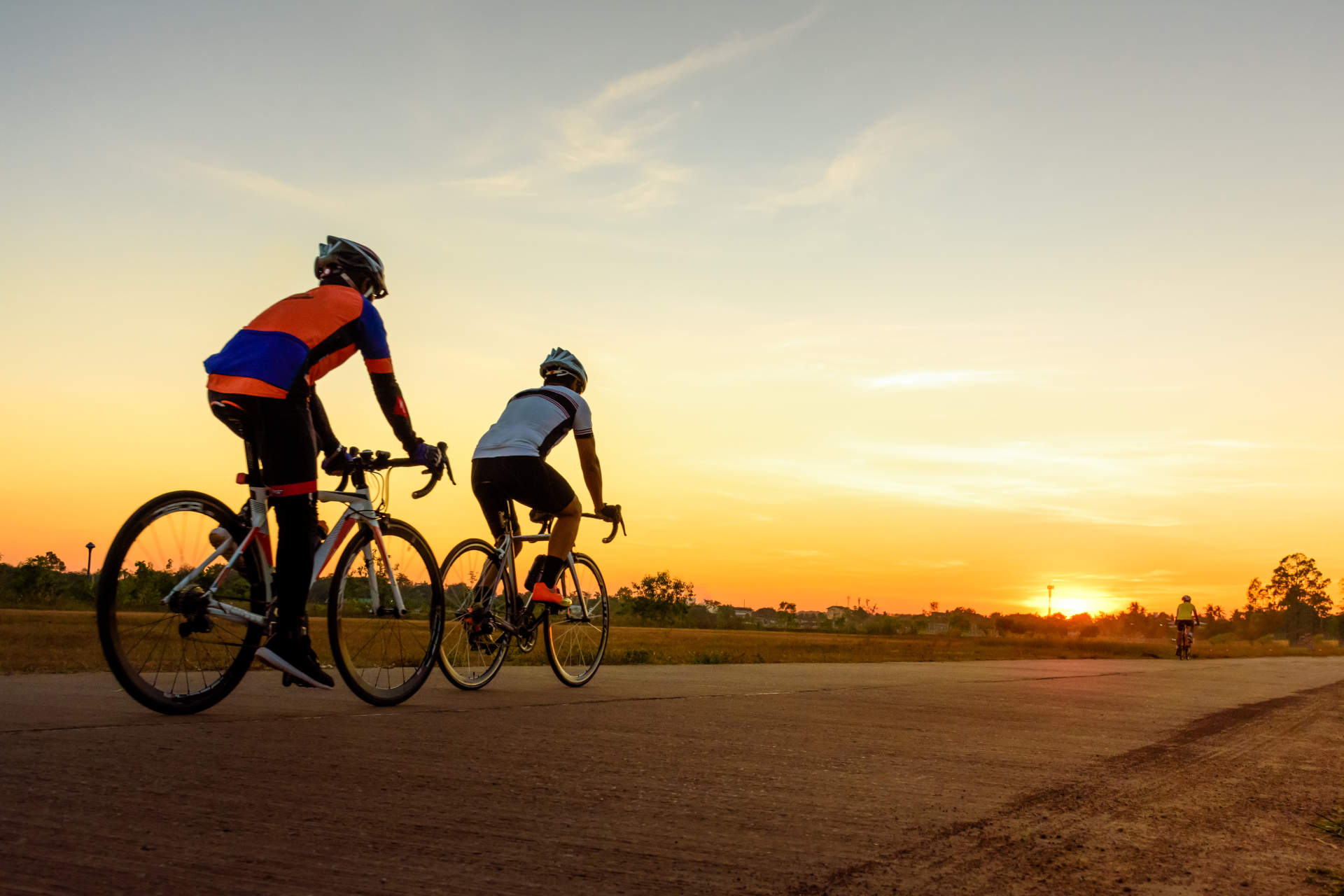 Was Sie bei Ihrer Mehrtagestour mit dem Fahrrad beachten sollten Zwei Fahrradfahrer machen eine Radtour in der Dämmerug