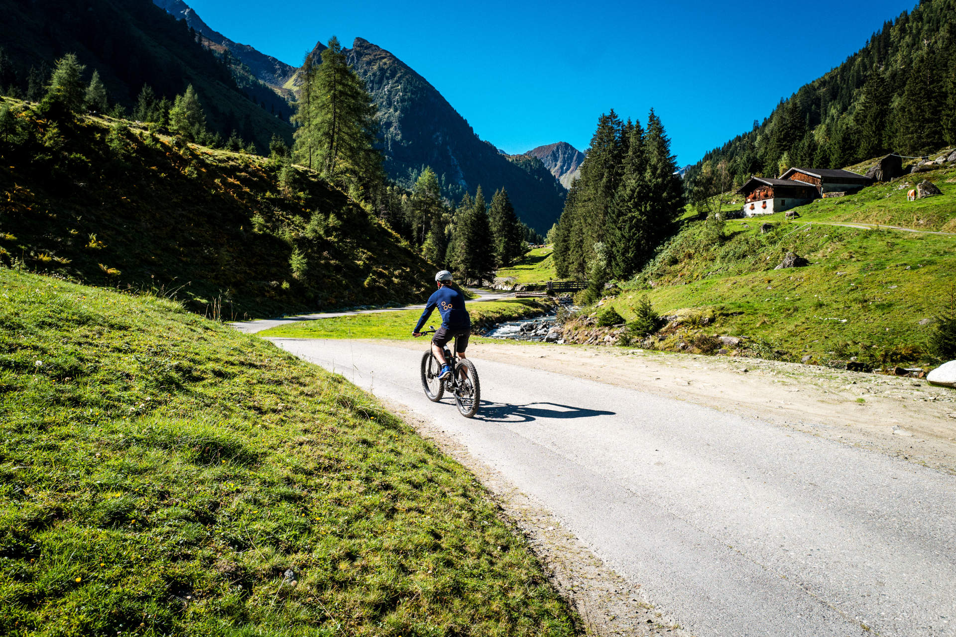 Mit dem Fahrrad über die Alpen - für den perfekten Radweg Ein Fahrradfahrer fährt durch die Berge
