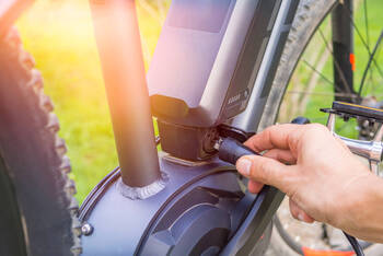 Eine E-Bike Batterie wird bedient