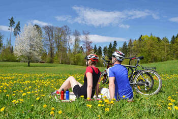 Ein Paar sitzt im Rasen mit ihren Fahrrädern