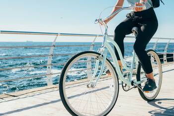 Frau auf Fahrrad in Vintage Optik am Meer