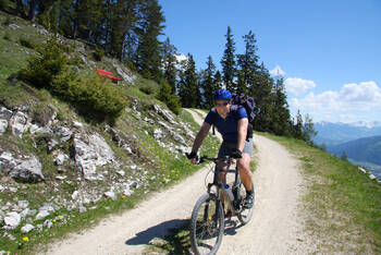 Ein Mann fährt mit dem Fahrrad einen Weg runter