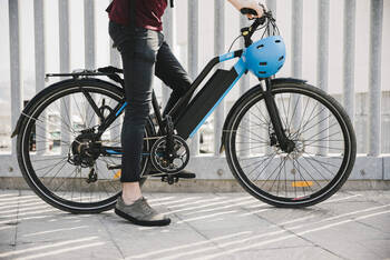 Person sitzt auf einem E-Bike