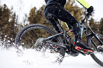 Person fährt auf E-Bike durch den Schnee