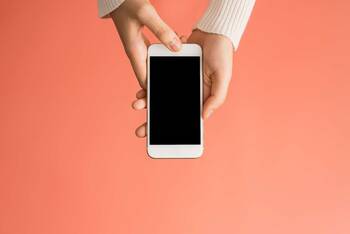 Person hält iPhone mit schwarzem Display in den Händen