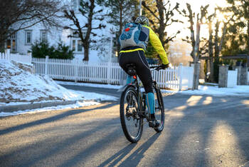 Fahrradfahrer fährt im Winter auf Straße