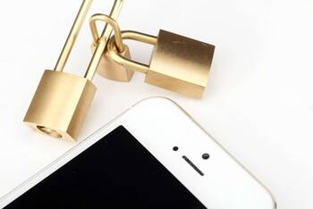 Schlösser ineinander verschlossen neben einem Handy