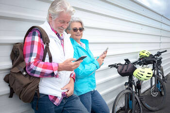 Zwei ältere Menschen schauen auf ihr Handy