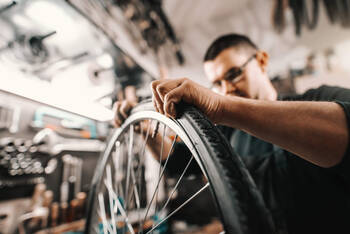 Mann repariert den Reifen eines Fahrrads