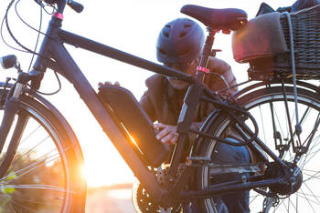 Ein Mann hält die Hände an den Akku eines E-Bikes