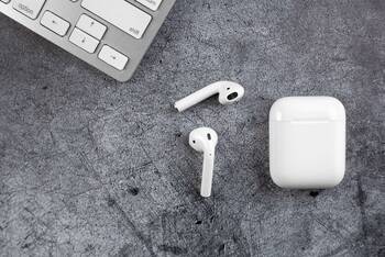 AirPods liegen auf grauer Unterlage