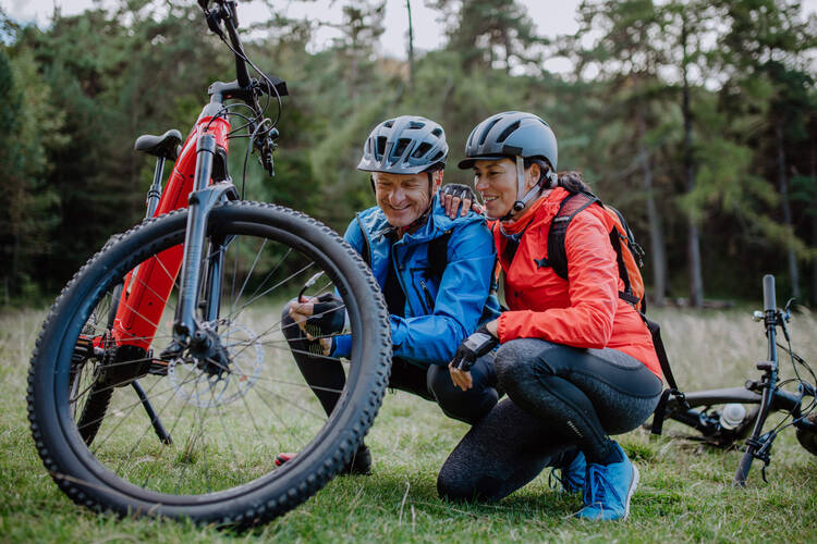 Ein Mann und eine Frau betrachten ihren E-Bike Reifen