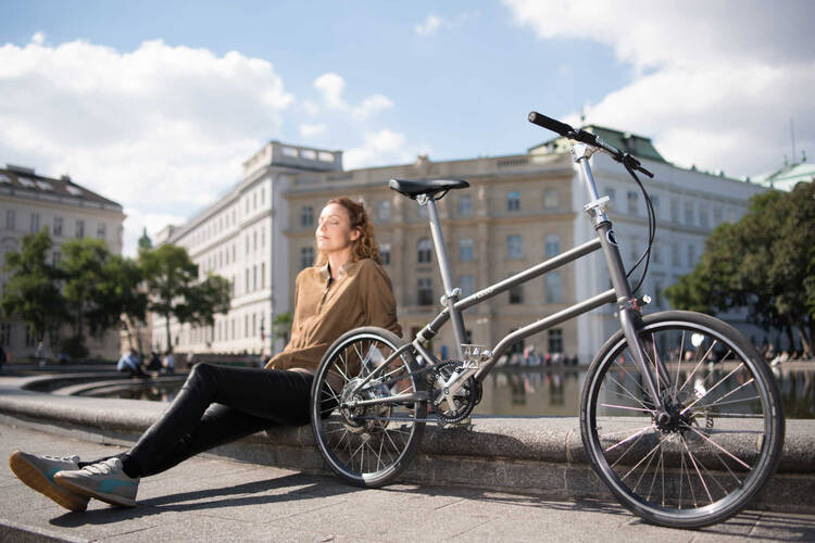 Frau sitzt neben Fahrrad