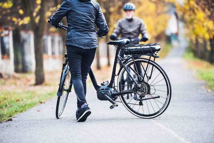 Eine Frau und ein Mann lenken ihre E-Bikes