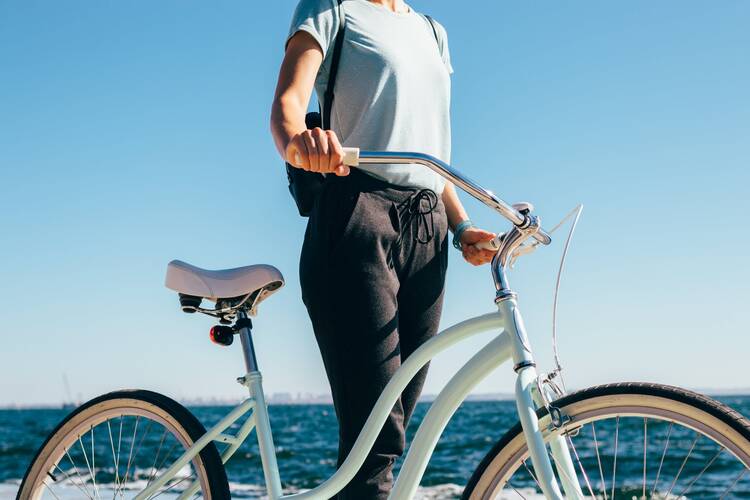 Frau mit Fahrrad in Vintage Optik am Meer