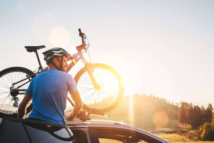 Fahrradträger für das Dach Person befestigt ein Fahrrad auf dem Fahrradträger für das Dach.