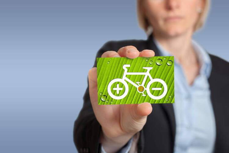 Eine Frau hält einen E-Bike Sticker in die Kamera
