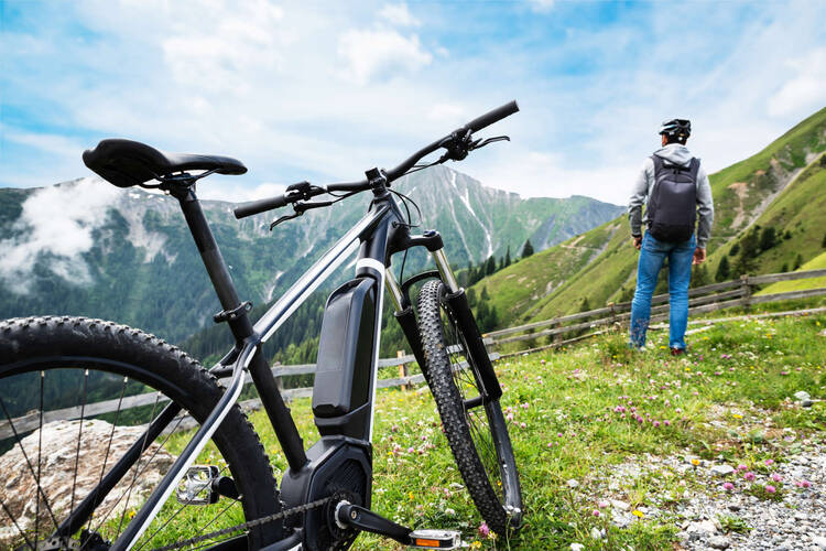 E-Bike in den Bergen, ein Mensch guckt in die Ferne