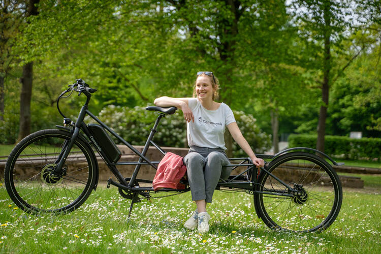 Frau sitzt auf einem Lastenrad von Convercycle