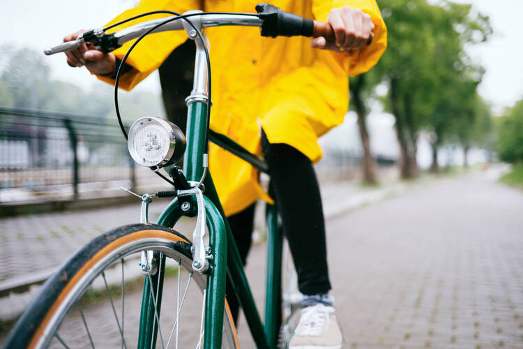 Person fährt mit einer Regenjacke Fahrrad