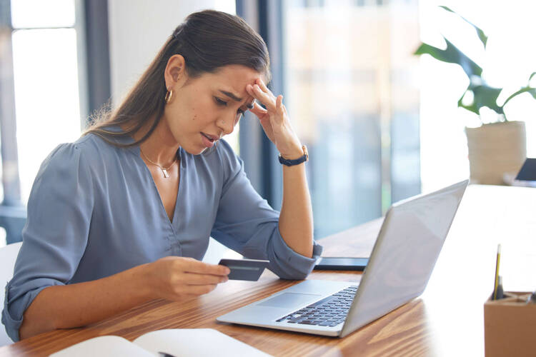 Frau verzweifelt vor Laptop wegen eines Fake-Shops