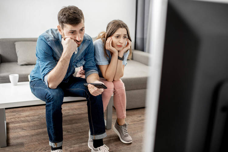 Mann und Frau sitzen verzweifelt vor dem Fernseher