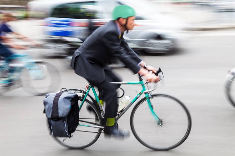 Mann fährt durch Stadtverkehr mit Fahrrad