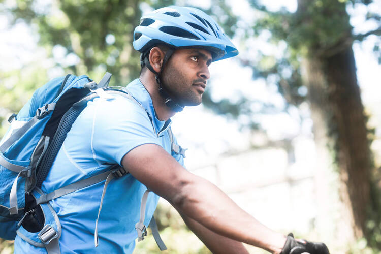 Junger Mann mit Helm und Trikot und Fahrrad