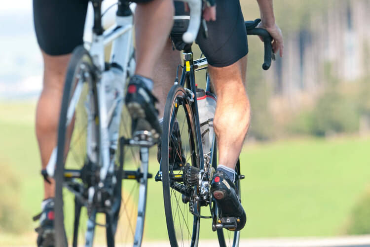 Close up von männlichen Beinen die Rennrad fahren
