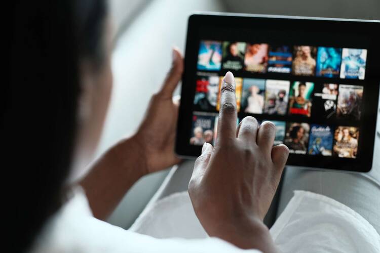 Person tippt in Netflix App auf Tablet