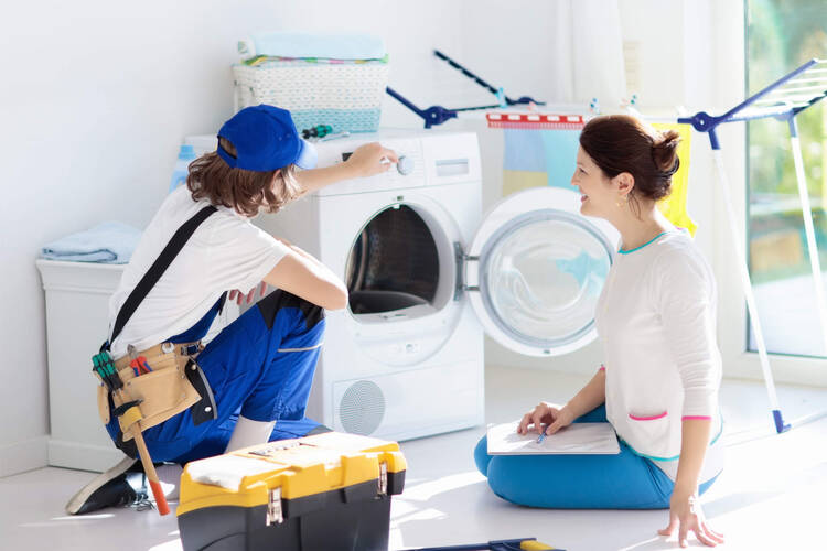 Frau sitzt mit Handwerker vor der Waschmaschine