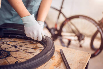 Person repariert ein Reifen eines Fahrrads
