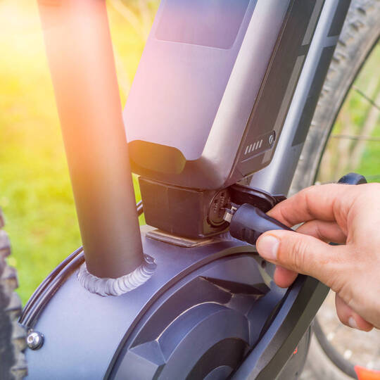 Eine E-Bike Batterie wird bedient