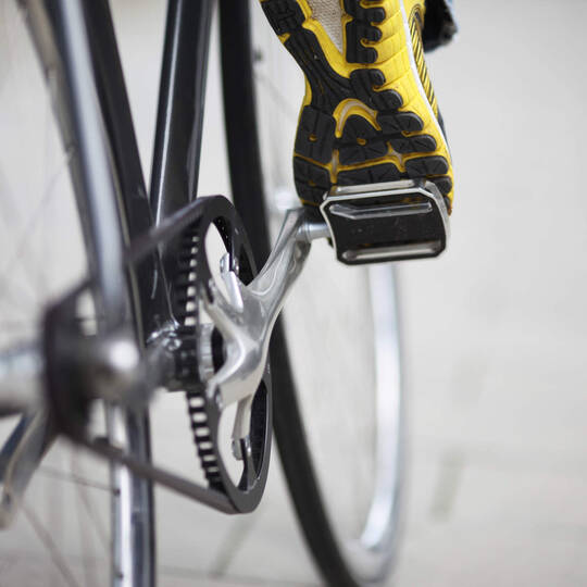 Ein Fuß dass auf ein Fahrradpedal trifft