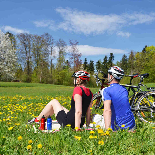 Ein Paar sitzt im Rasen mit ihren Fahrrädern