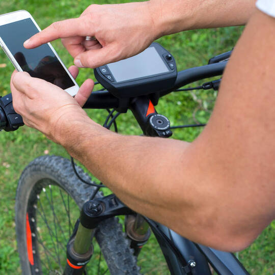 Ein Handy neben einem E-Bike Display