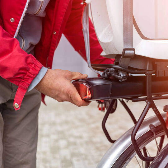 Person prüft das Rücklicht eines Fahrrads