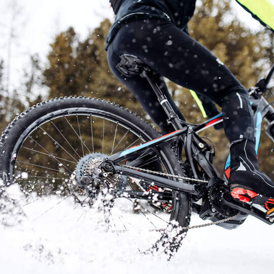 Person fährt auf E-Bike durch den Schnee