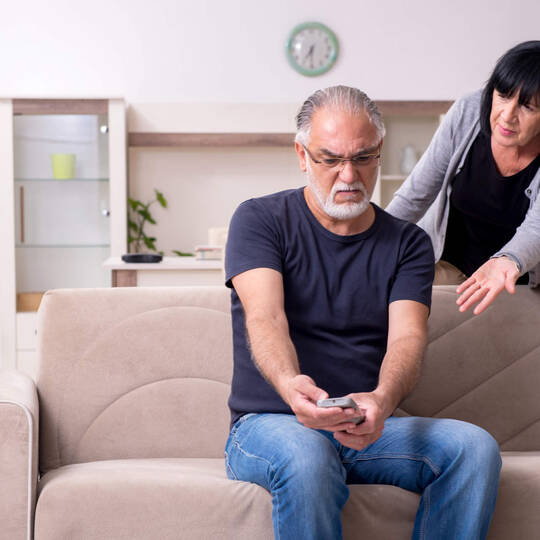 Wenn der Fernseher kein Signal hat – Das sollten Sie tun Mann und Frau sitzen verzweifelt vor dem Fernseher