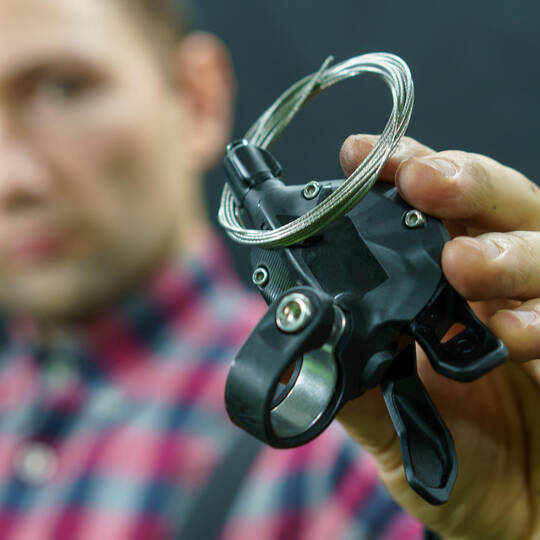 Mann hält Teil einer Fahrradschaltung in der Hand