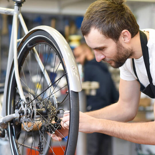Person pflegt seine Fahrradkette 