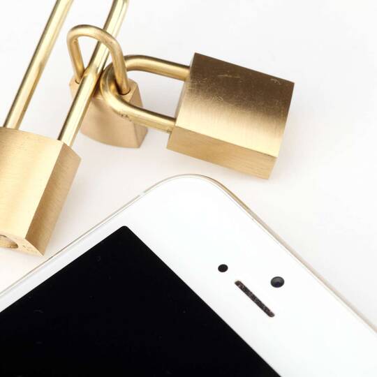Schlösser ineinander verschlossen neben einem Handy