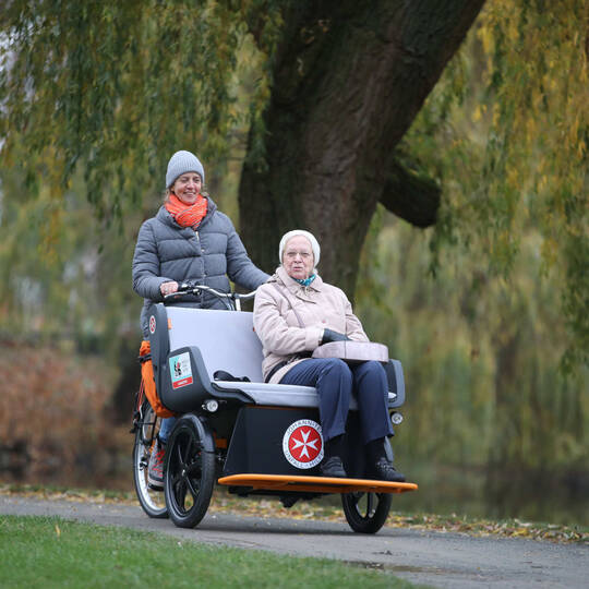Ältere Person wird in einer Rikscha transportiert