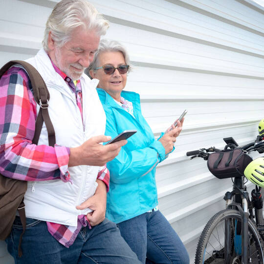 Zwei ältere Menschen schauen auf ihr Handy
