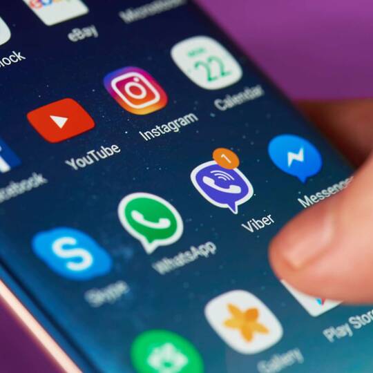 WhatsApp Chats auf neues Handy übertragen Smartphone zeigt verschiedene Apps im Hauptmenü.